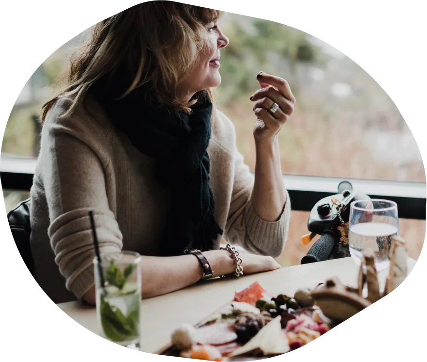 A woman sitting at an outdoor table enjoying a meal
